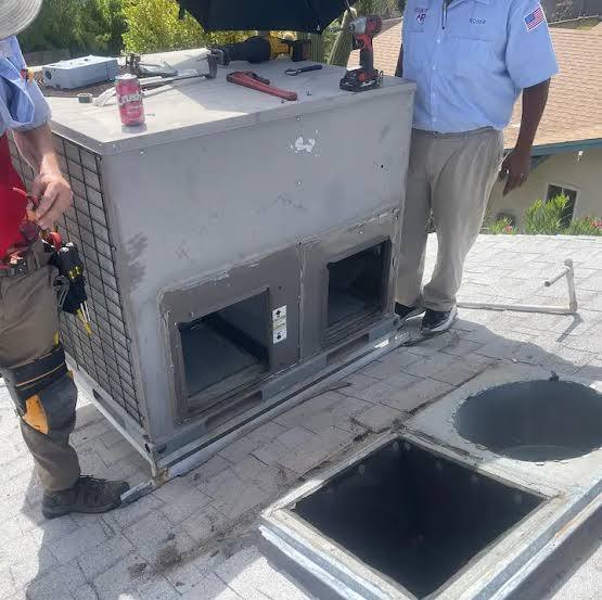 Crew removing an old rooftop unit during a changeout