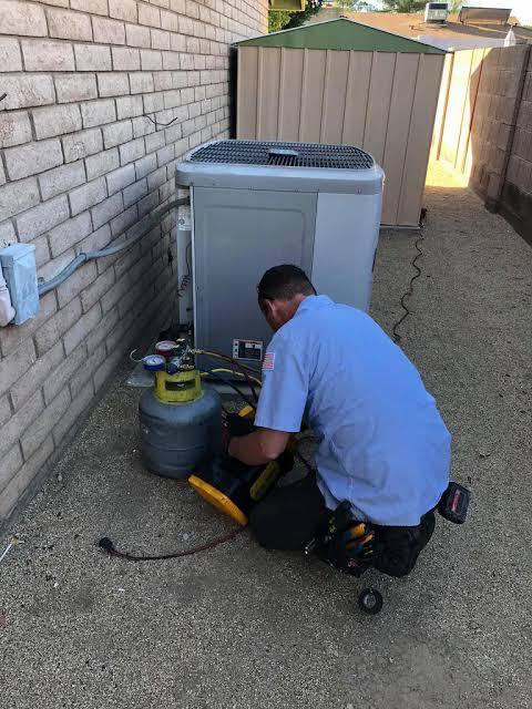 Patriot Air technician performing refrigerant service on a residential AC unit